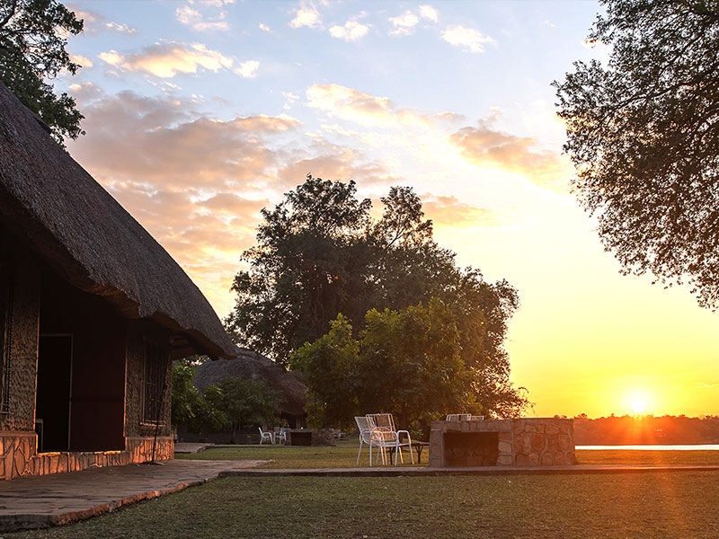 A thatched riverside chalet at sunset on the Zambezi